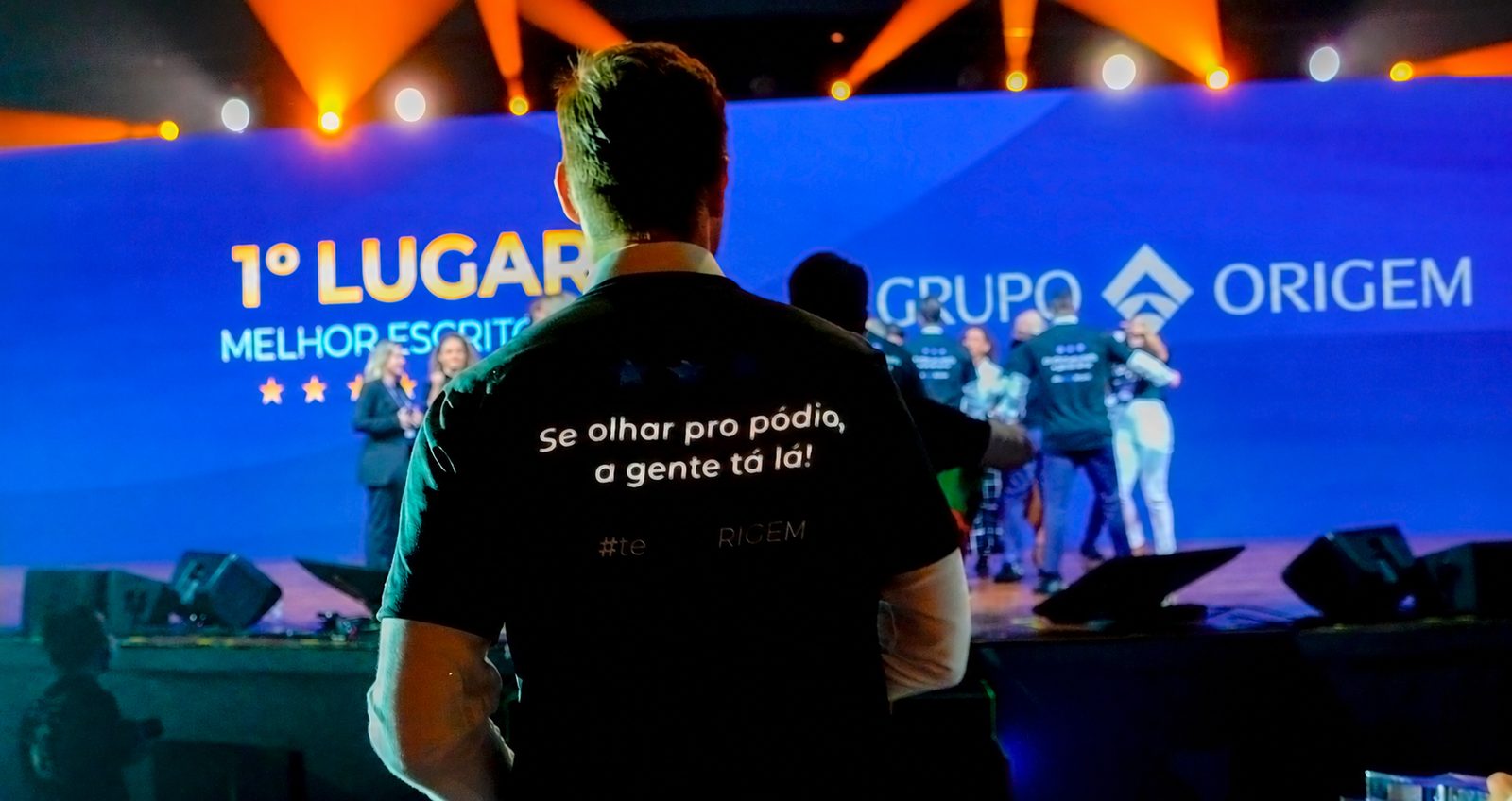 Time do Grupo Origem no palco de premiação